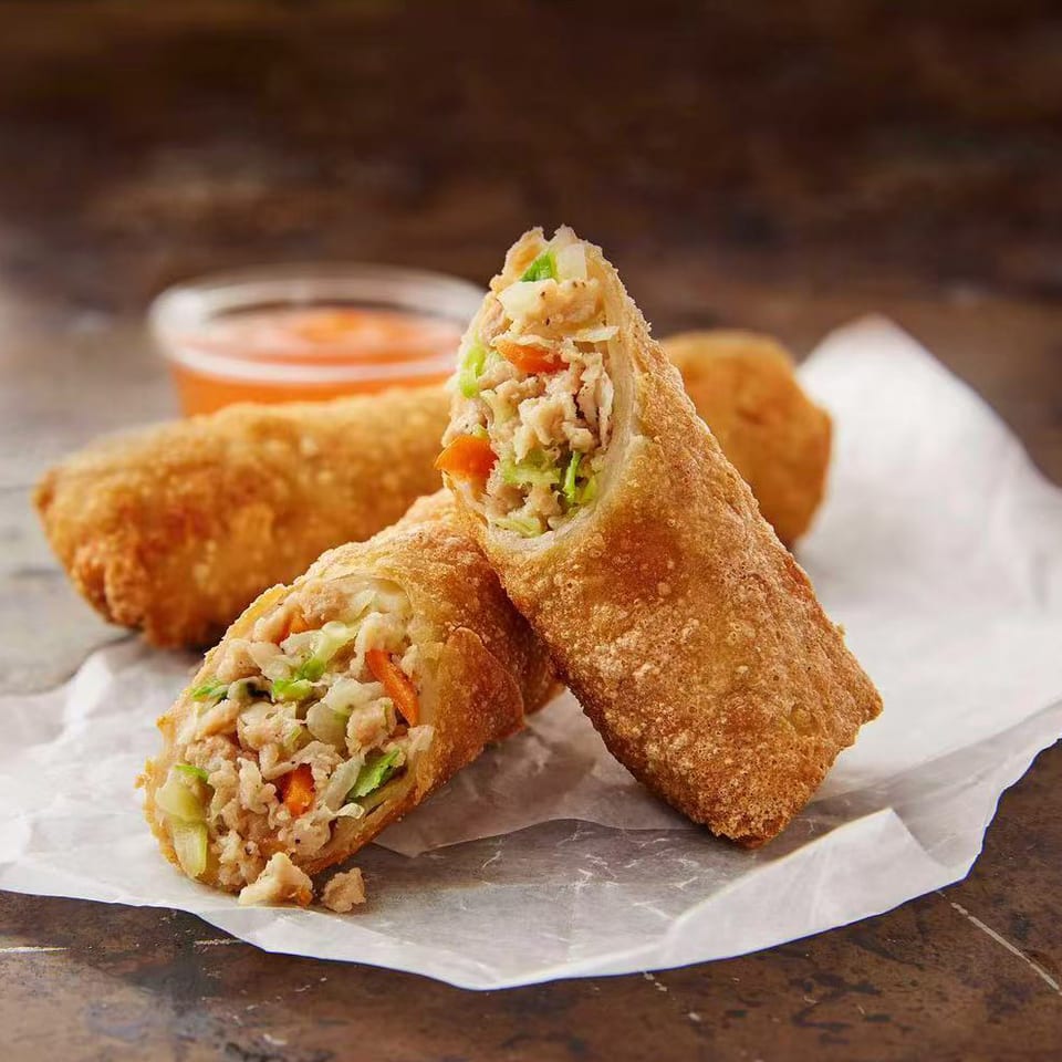 Golden egg rolls with dipping sauce.