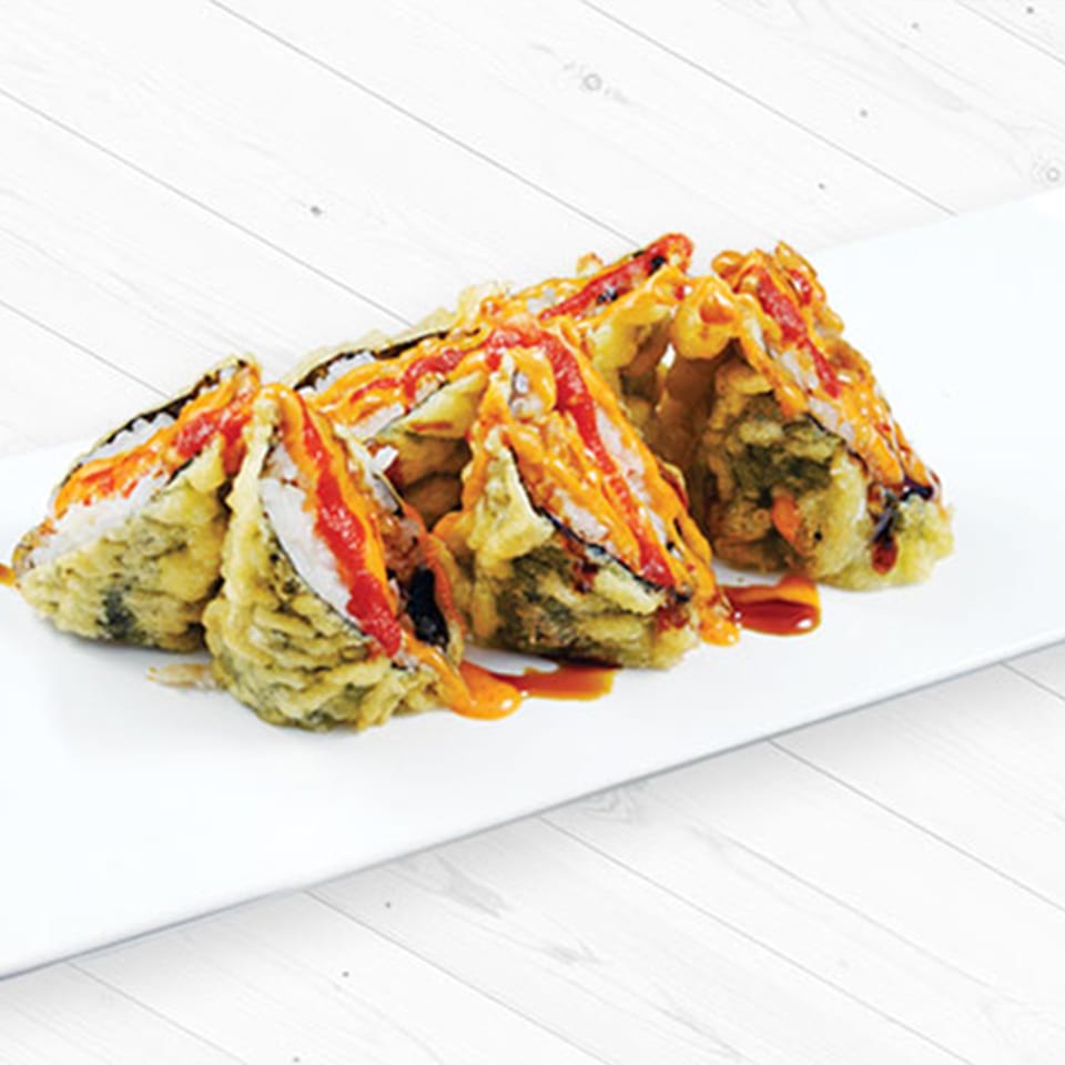 Crispy sushi pieces drizzled with sauces on a white platter.